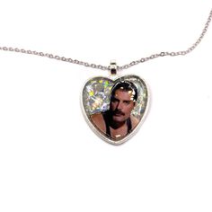 Add a unique and charming touch to your accessory collection with this original FREDDIE MERCURY necklace! Perfect for Queen fans. This necklace features a heart-shaped pendant with an image of FREDDIE MERCURY, with a holographic effect glitter background. 𝗣𝗥𝗢𝗗𝗨𝗖𝗧 𝗗𝗘𝗧𝗔𝗜𝗟𝗦  ✨Unique Design: The pendant showcases a crisp image encapsulated in a heart with a glittery background that shines in the light. A unique, handmade piece.  📏Perfect Size: The pendant is appropriately sized (2.5 c Mercury Necklace, Glittery Background, Glitter Necklace, Sparkling Rings, Glitter Background, Holographic Glitter, Freddie Mercury, Stainless Steel Chain, Heart Necklace