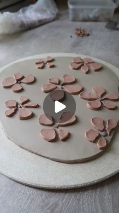 a cake is decorated with pink flowers and icing on a white platter in the process of being made