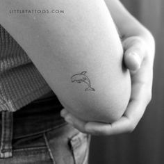 a small dolphin tattoo on the arm