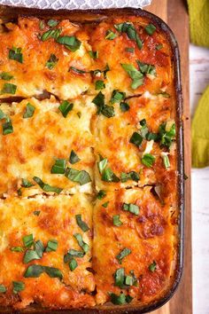 a casserole dish with cheese and herbs on top, ready to be eaten