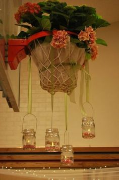 flowers in mason jars hanging from the ceiling