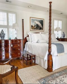 a large bed sitting in the middle of a bedroom next to a dresser and chair