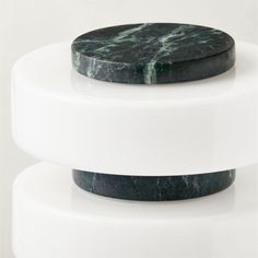 two black and white marble coasters sitting on top of each other in front of a white background