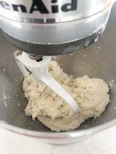 a metal bowl filled with dough next to a mixer