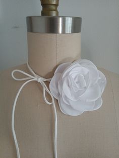 a mannequin torso with a white flower on the front and back of it