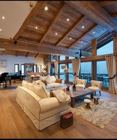 a living room filled with furniture next to a large window covered in wood planks