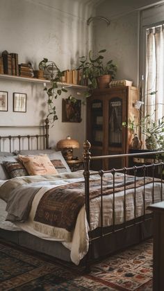 a bed sitting in a bedroom next to a window with lots of plants on top of it