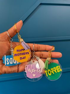 someone holding three different keychains in their hand with the words happy mother's day written on them