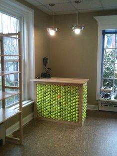 a counter made out of tennis balls in front of a window with ladders to the side