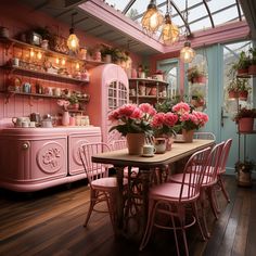 a dining room with pink furniture and potted flowers on the table in front of it