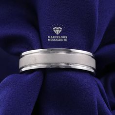 a close up of a ring on top of a purple cloth with the logo marvelous moussanite