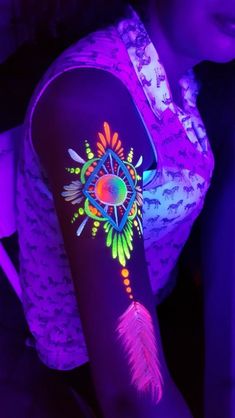 a woman with her arm covered in neon tattoos