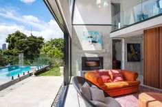 a living room filled with furniture next to a large glass window overlooking a swimming pool