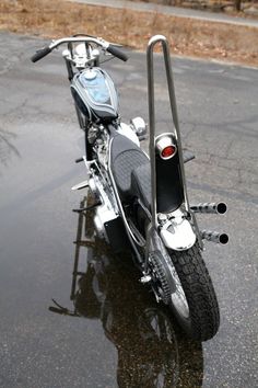 the motorcycle is parked on the wet pavement