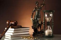 an hourglass, statue and books on a table