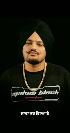 a man with a turban on his head wearing a black t - shirt