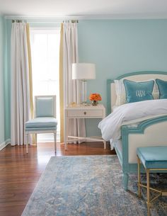 a bedroom with blue walls and white furniture