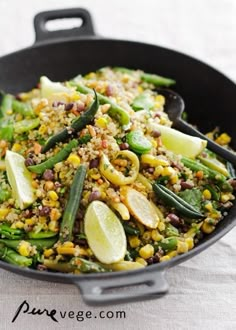 a skillet filled with green beans, corn and other vegetables on top of a table