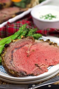 a close up of a plate of food with meat and asparagus on it