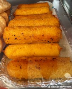 bread sticks are lined up on tin foil next to other food items in a display case