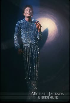 michael jackson singing into a microphone in front of a dark background with the words michael jackson on it