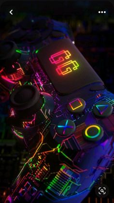 a close up view of a controller with neon lights on the top and bottom part