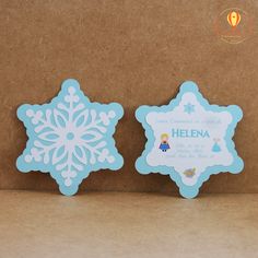 two snowflake shaped cards sitting next to each other on top of a cardboard box