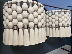 several white tassels hanging from a metal bar