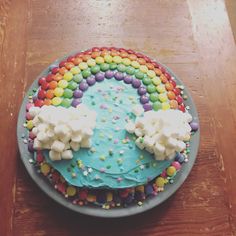 a cake with blue frosting and sprinkles on a wooden table top