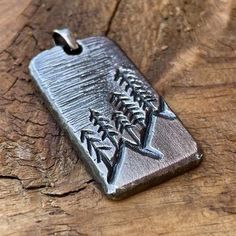 a metal pendant with an image of a fish on it's back and the word,