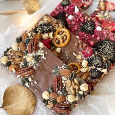 two pieces of chocolate with nuts and pretzels on top