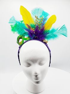 Mardi Gras headband made with purple, gold and green feathers with gold sparkle embellishments. Green masquerade mask with gold glitter detail and feathers. Headband wrapped with purple ribbon. Perfect for Mardi Gras celebration, carnival, festival or photoshoot. Adjustable Masquerade Mask For Mardi Gras, Gold Mardi Gras Eye Mask, Gold Costume Accessories For Mardi Gras Carnival, Green Masquerade Mask For Mardi Gras Party, Carnival Party Headpiece With Feathers, Headband For Mardi Gras Carnival, Purple Masquerade Mask For Mardi Gras Carnival, Gold Headpiece For Mardi Gras Carnival, Carnival Costume Hats And Headpieces With Matching Headband