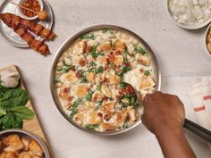 a person is stirring some food in a pan on the table next to other dishes