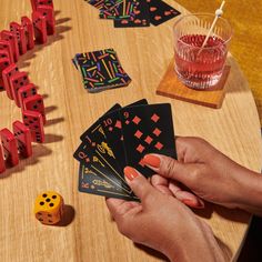 a person playing cards on a table with dices