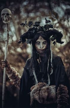 a woman with long hair holding a stick in her hands and wearing a wreath on her head