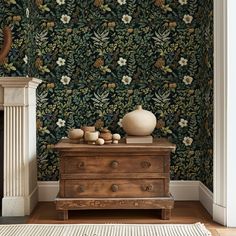 a living room with floral wallpaper and wooden dresser