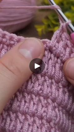 someone is knitting the stitchs on their pink sweater