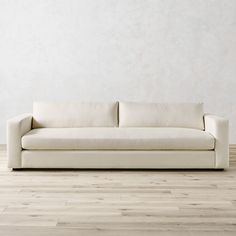 a white couch sitting on top of a hard wood floor