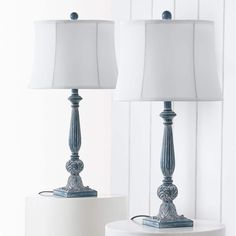 two lamps sitting next to each other on top of a white table with blue trim