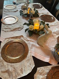 the table is set with plates and candles