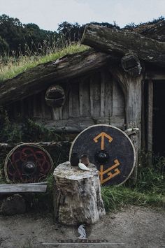 there is a wooden structure with a sign on it and a tree stump in front of it