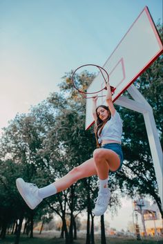 a girl is playing basketball in the park