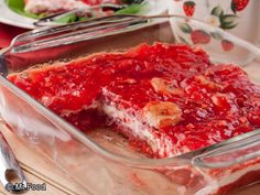 a close up of a cake in a pan on a table with plates and utensils