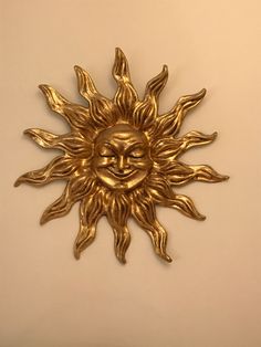 a gold sun face on a white wall