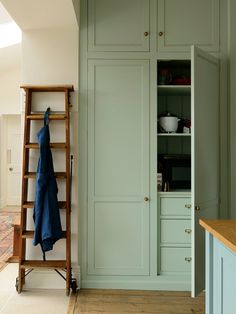 a kitchen with green cabinets and wooden floors