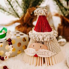 an origami christmas tree made out of old book pages and other decorations on a table