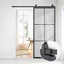 an open glass door with a black handle on the side and a white wall behind it