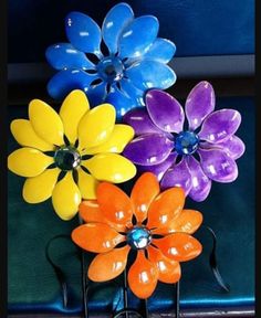 four colorful flowers are sitting on a table