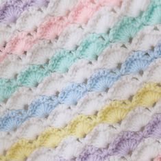 a crocheted blanket with multicolored stripes