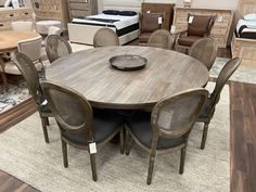 a large table with chairs around it in a room filled with furniture and mattresses